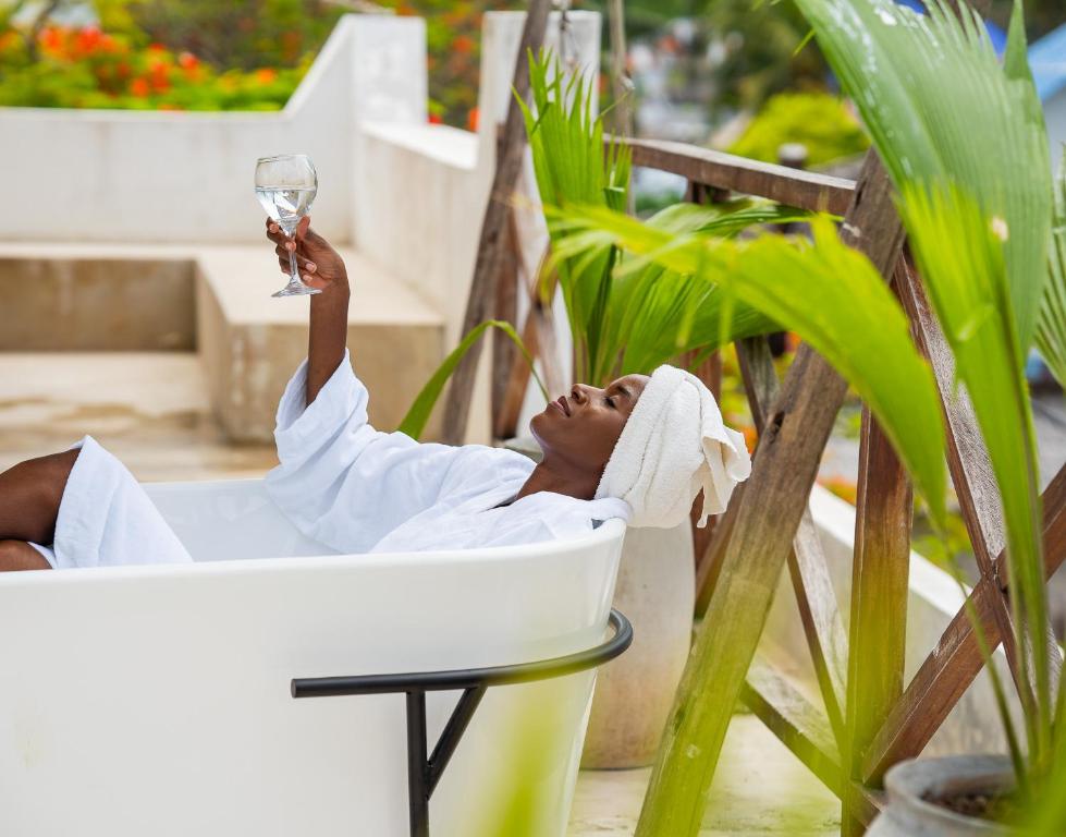 a woman laying in a chair with a glass of wine at ZAN Tropical Beach Adults Only in Dimbuni