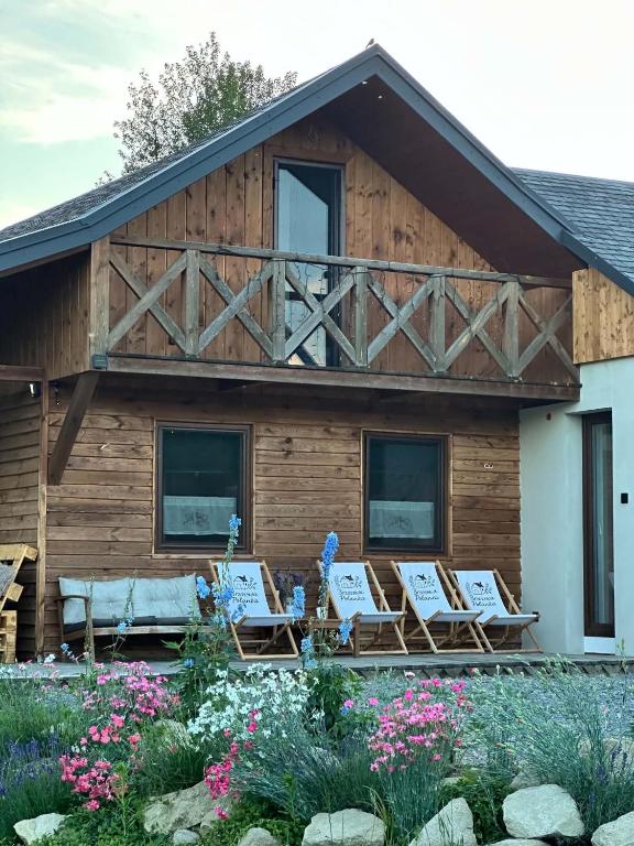 a house with a deck with chairs and flowers at Brzozowa Polanka II in Lipowiec Stary