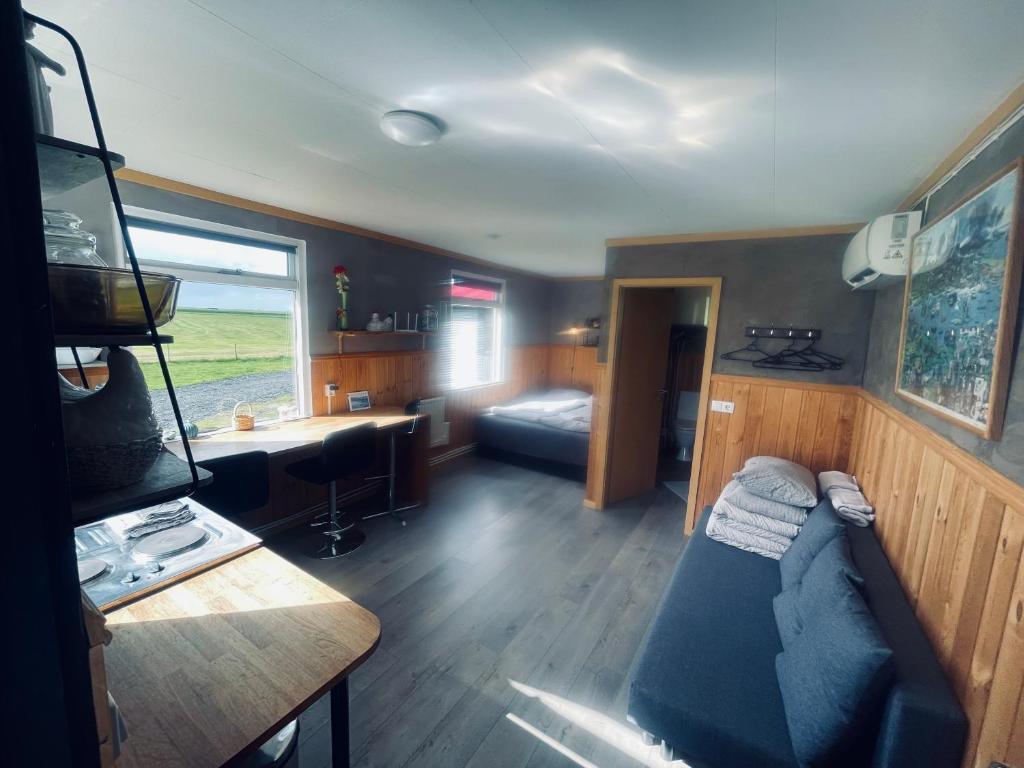 a living room with a couch and a bed in it at Vestra-Fíflholt cabin 3 in Hvolsvöllur