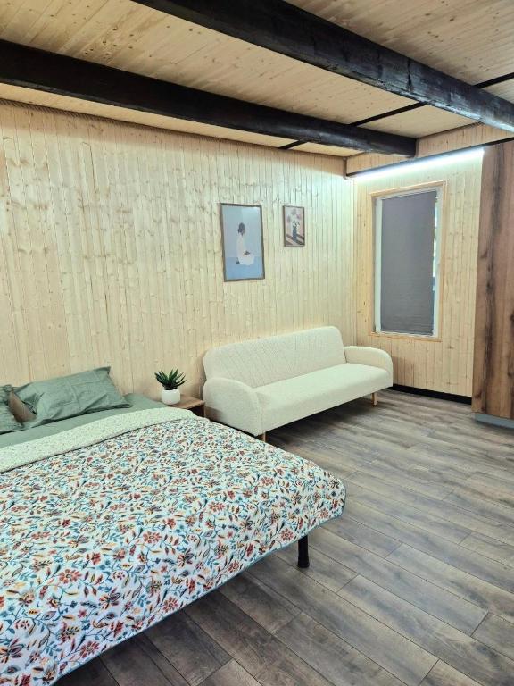 a bedroom with a bed and a couch at Sunpark in Vadul lui Vodă