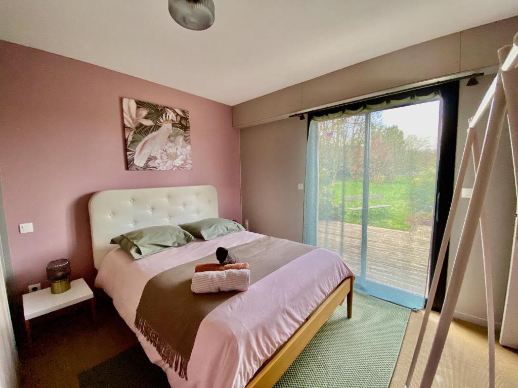a bedroom with a large bed and a large window at Le Domaine d'Elissois in Saint-Nicolas-de-Redon