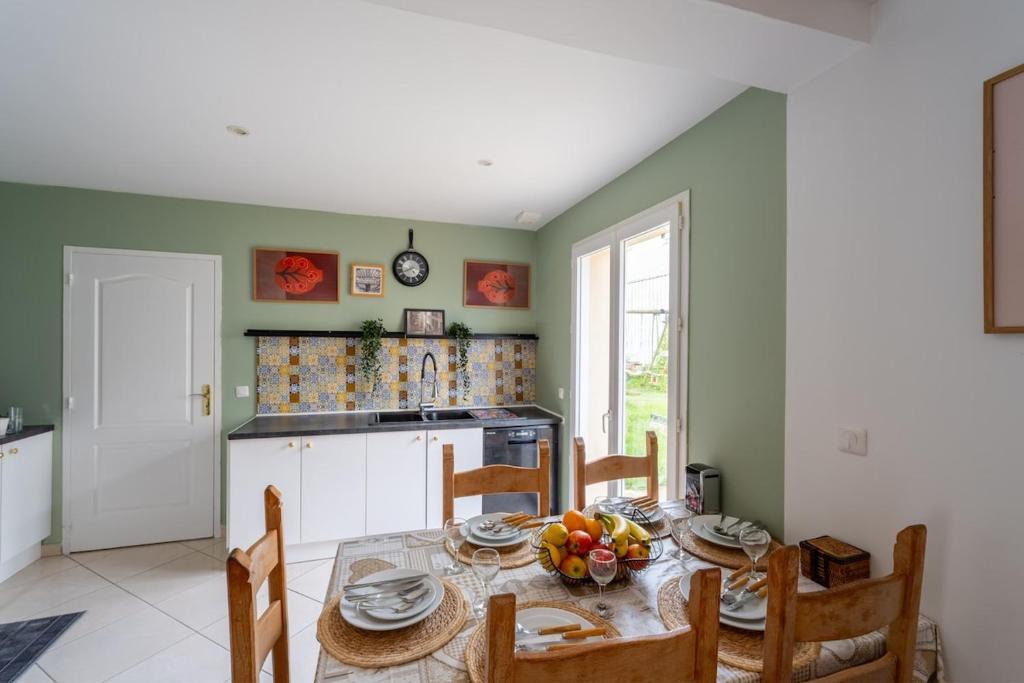a kitchen with a table with fruit on it at La Maison du Bonheur - Appartements & Chambres à Gisors in Gisors