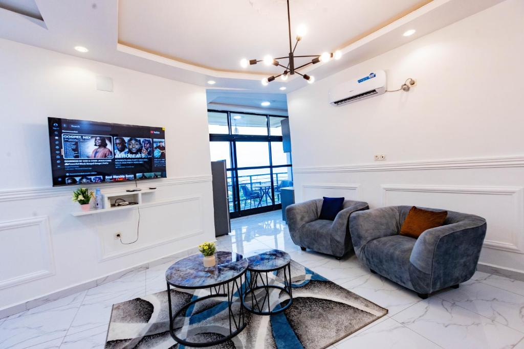 a living room with two couches and a flat screen tv at Moonlight heaven suites in Limbe