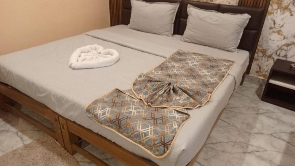 a bed with two blankets on top of it at Theglassystay in Raipur