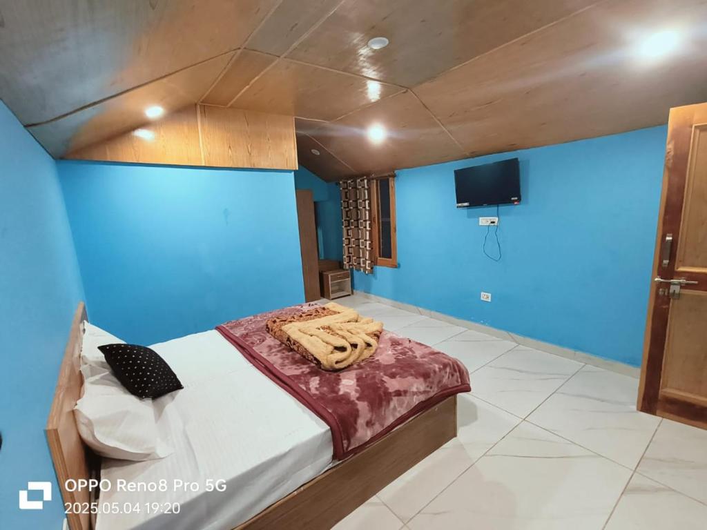 a bedroom with a bed with a blue wall at Mahi camping in Jagatsukh