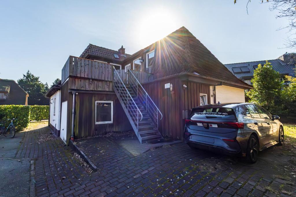 a house with a car parked in front of it at Appartement Tümmelkoje in Sankt Peter-Ording