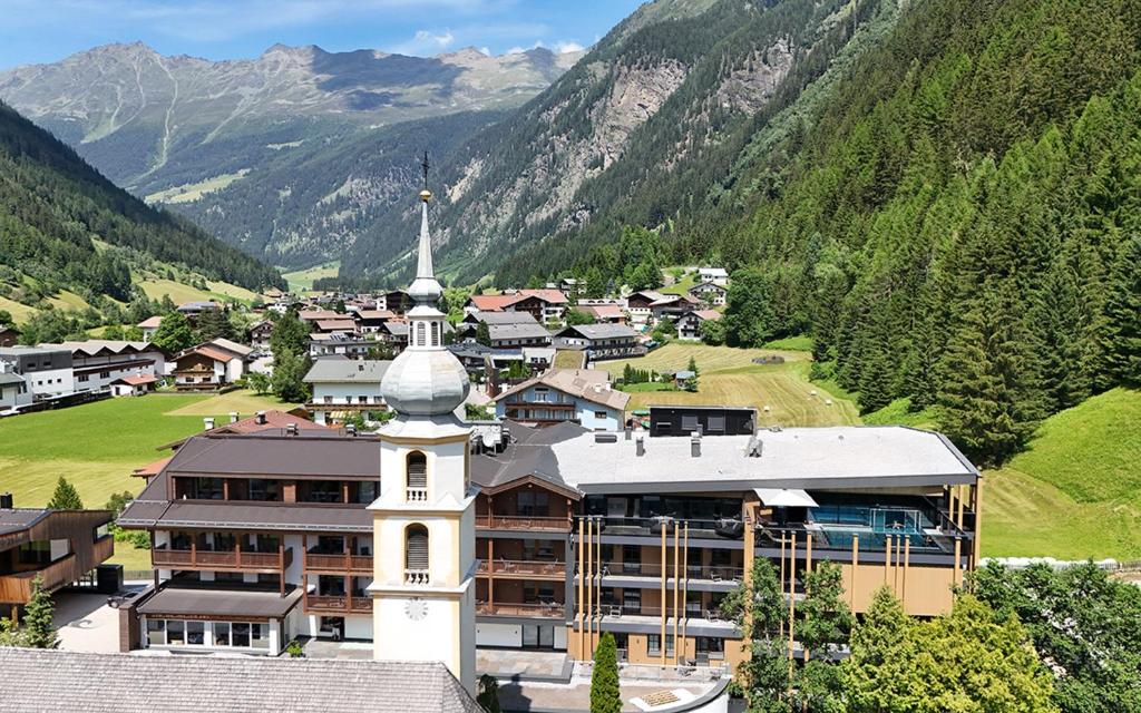 a small town with a church in the mountains at Hotel Kirchenwirt in Kaunertal