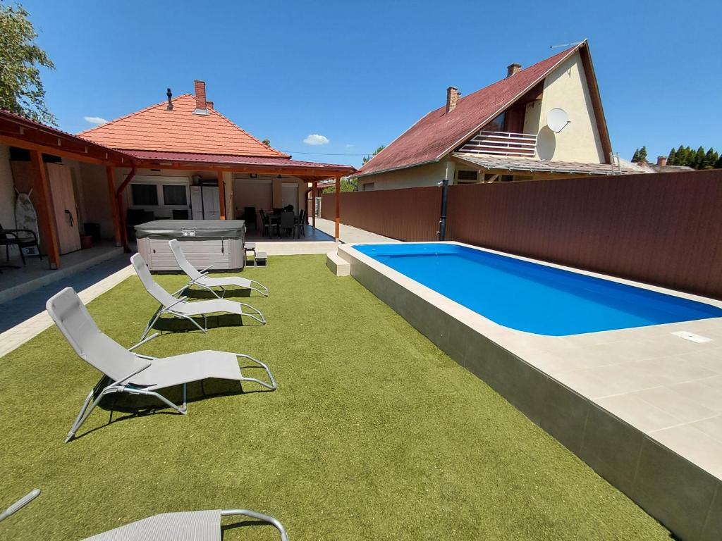 a backyard with chairs and a swimming pool at Borti Apartman in Zamárdi