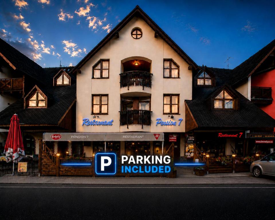 a large white building with a parking involved at Wellness Pension 7 in Harrachov