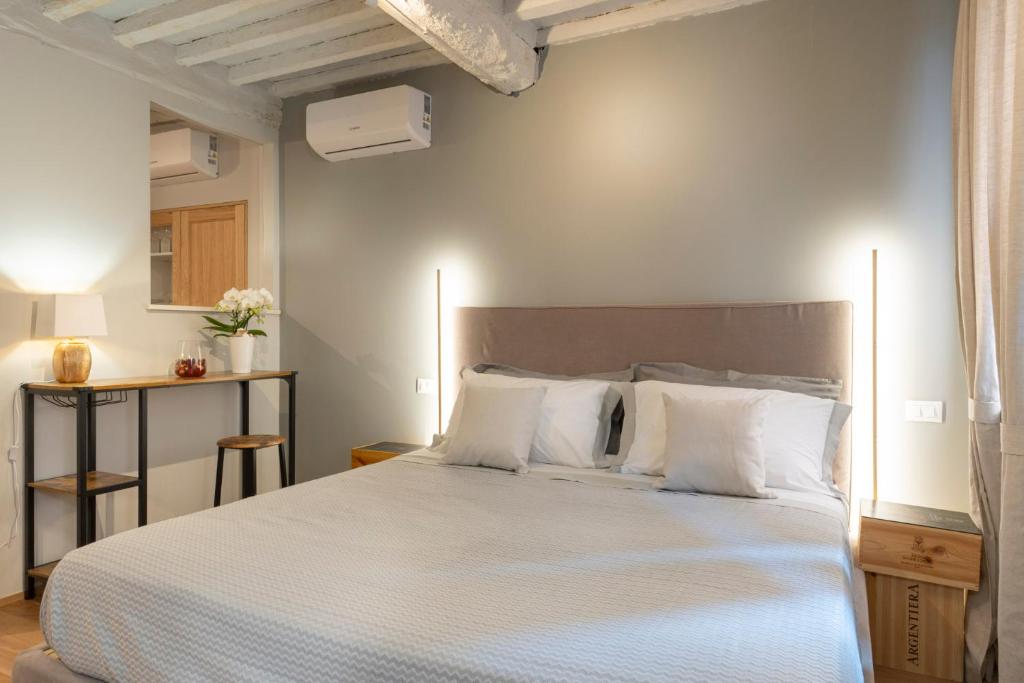 a bedroom with a white bed with white pillows at La Piccola Atene Atelier in Pietrasanta