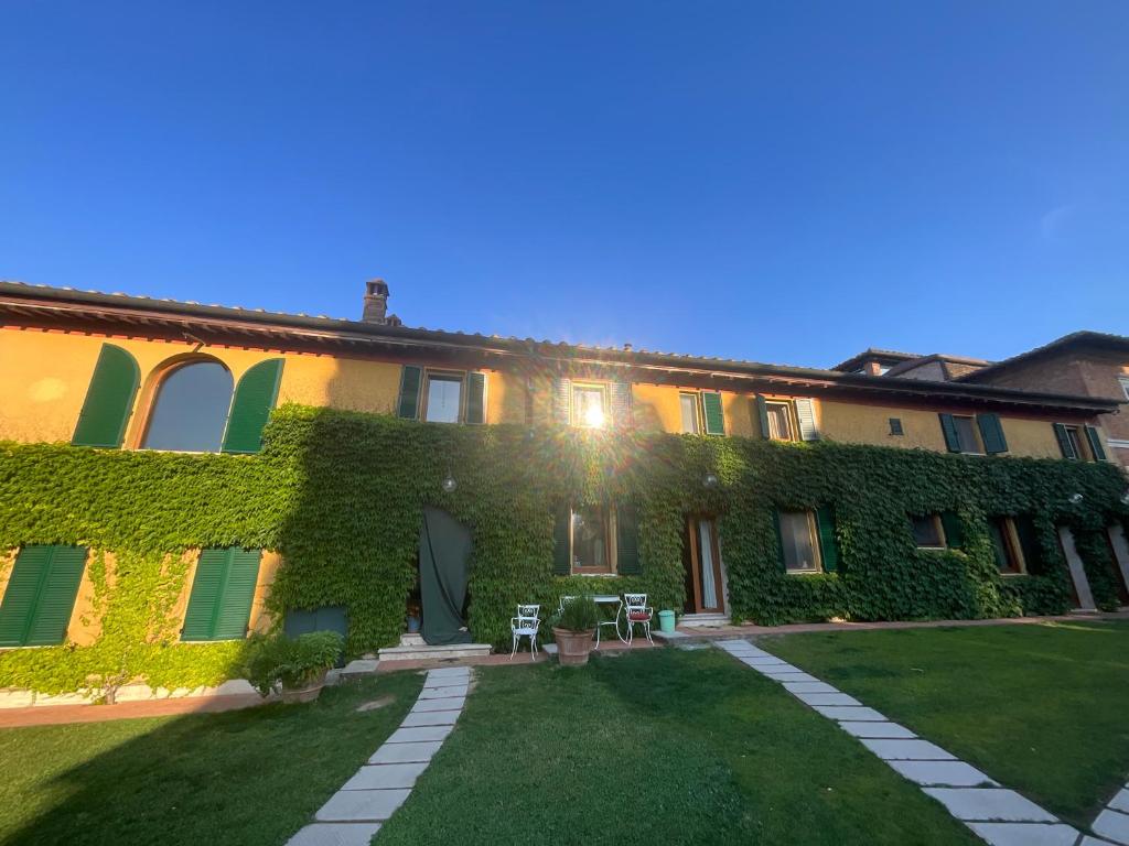 an ivy covered building with a yard at Villa Santa Chiara in Siena