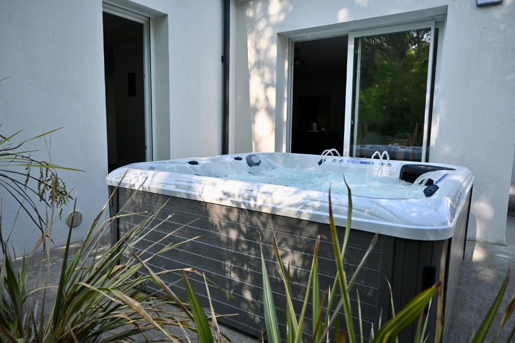 a bath tub sitting outside of a house at Maison moderne avec spa et jardin sans vis-à-vis, idéal professionnels et familles - L'ÉCRIN BRETON in Vannes