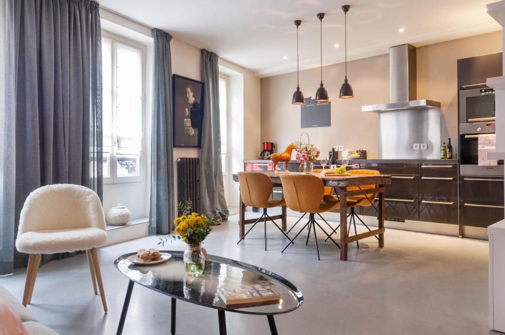 uma cozinha e sala de estar com mesa e cadeiras em Le Gourmet du Marais em Paris
