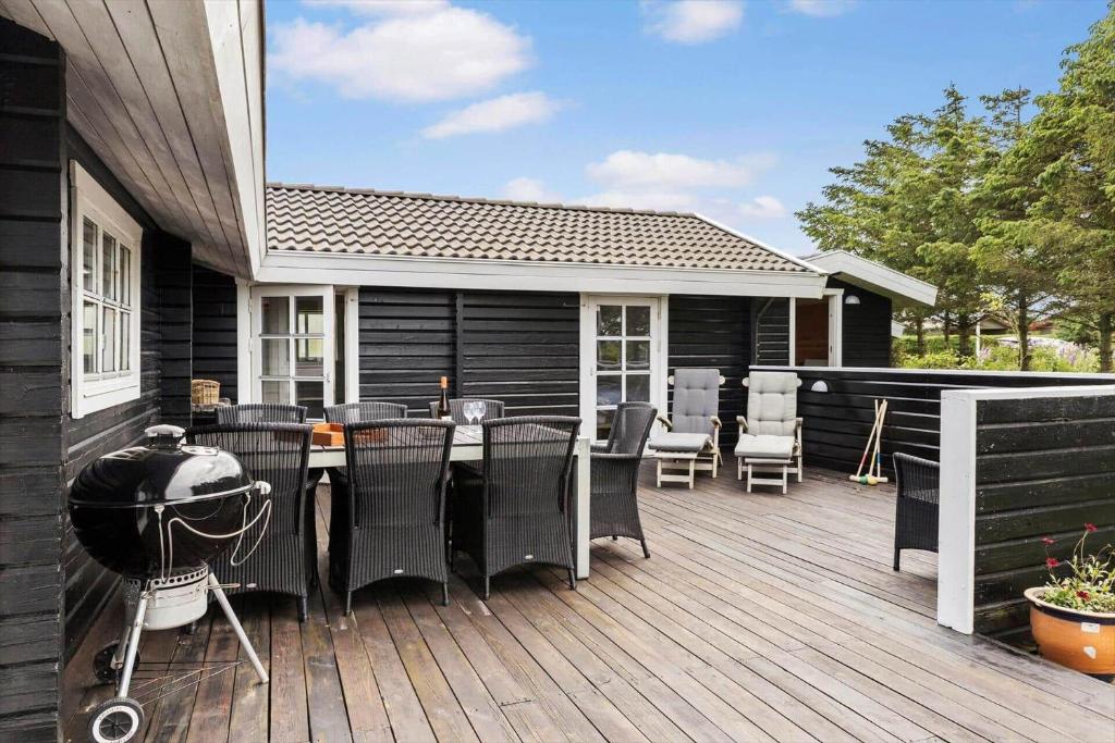 a deck with a grill and chairs on a house at LN1926-Hjorring-Jollevej-2 in Hjørring