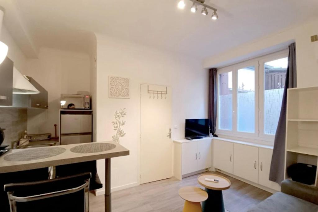 a kitchen with a table and a large window at Bright and quiet studio in Nice in Nice