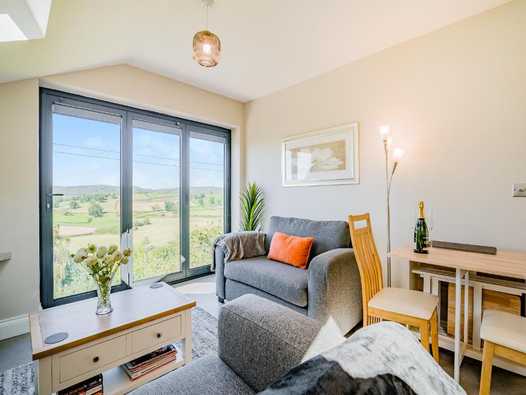 a living room with a couch and a table at Wye Nest in Fownhope