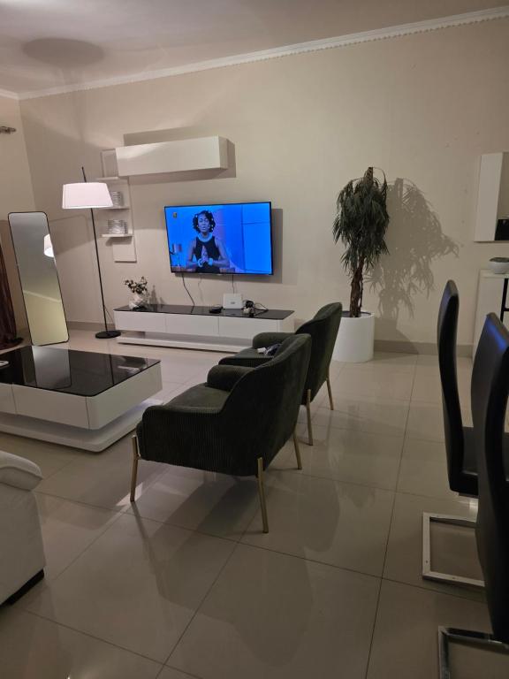 a living room with chairs and a flat screen tv at L28 double up apartament in Camama