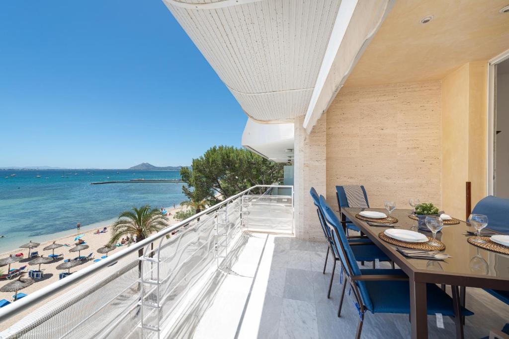 a balcony with a table and chairs and the beach at Port de Pollenca Esmeralda 3 in Port de Pollensa