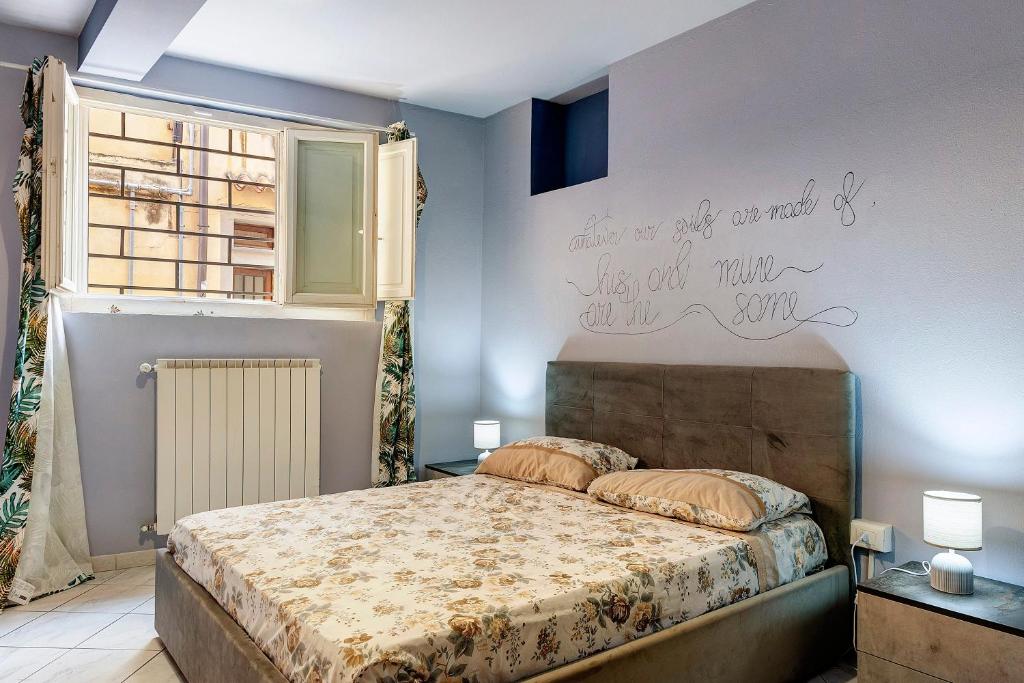 a bedroom with a bed with writing on the wall at Dimora il Respiro di Pisa in Pisa