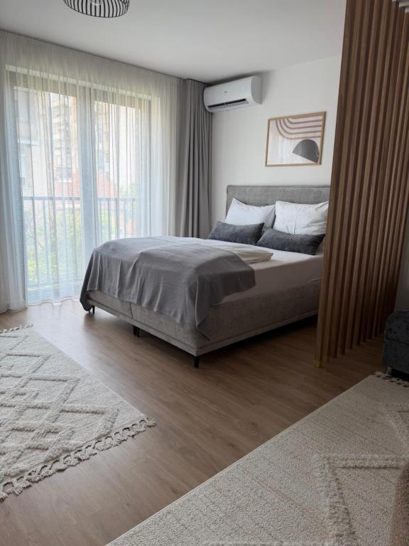 a bedroom with a bed and a large window at SARAJEVO SUITES No 23 Free parking in Sarajevo