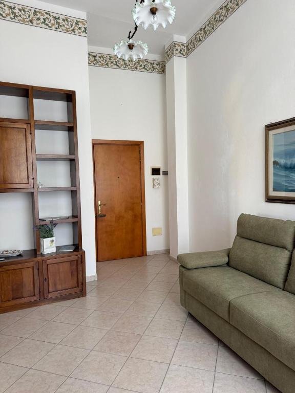 a living room with a couch and a wooden door at Casa FERRIGNO in Portoferraio