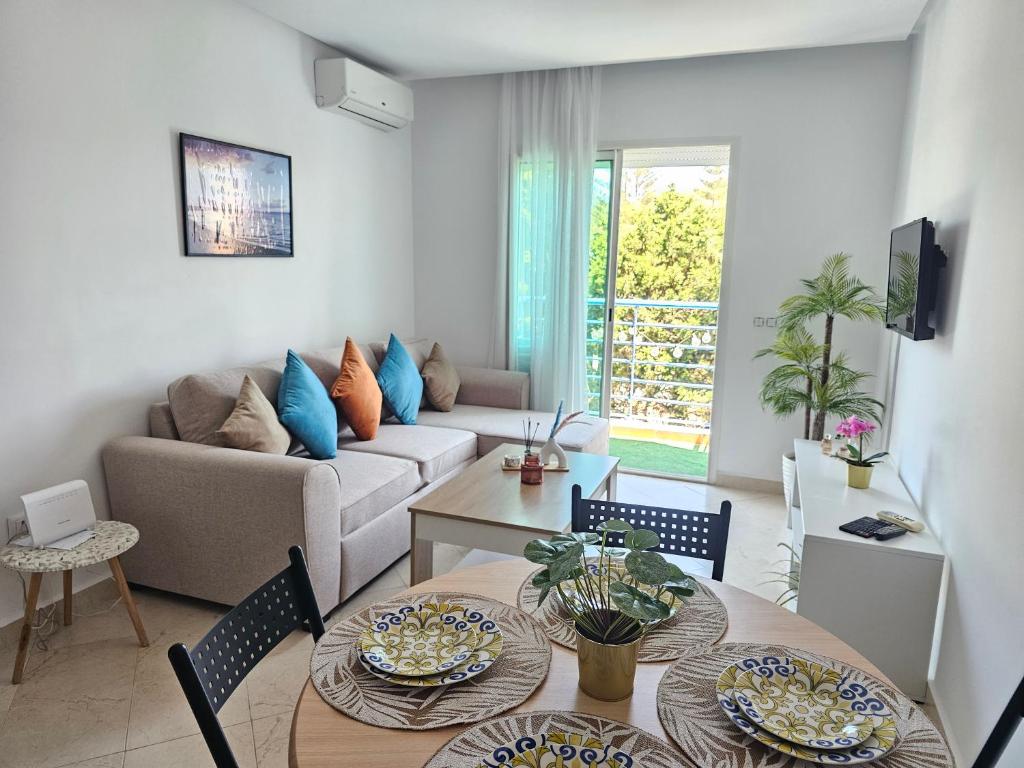 a living room with a couch and a table and chairs at Cabo Alegre in Martil