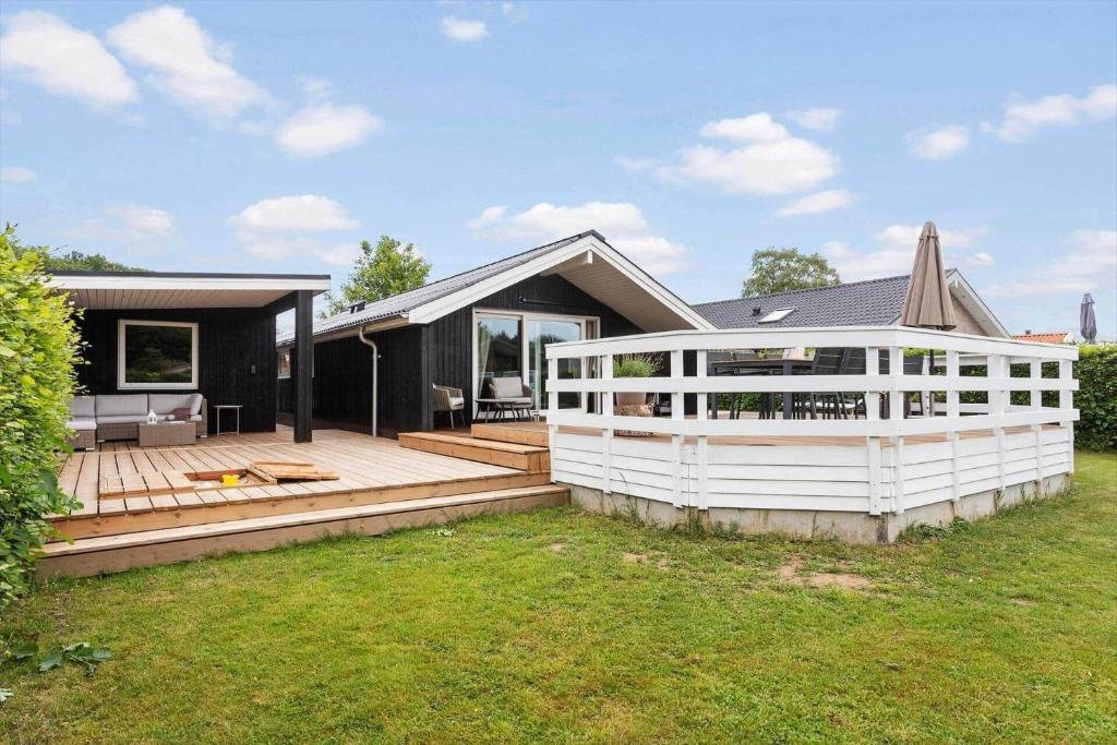 a house with a wooden deck in the yard at sj278-Bjert-Binderup-Strandpark-80 in Åbjerg