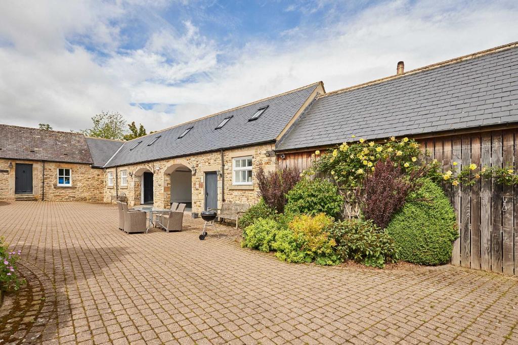 a brick house with a courtyard in front of it at Host & Stay - The Spinney in Consett