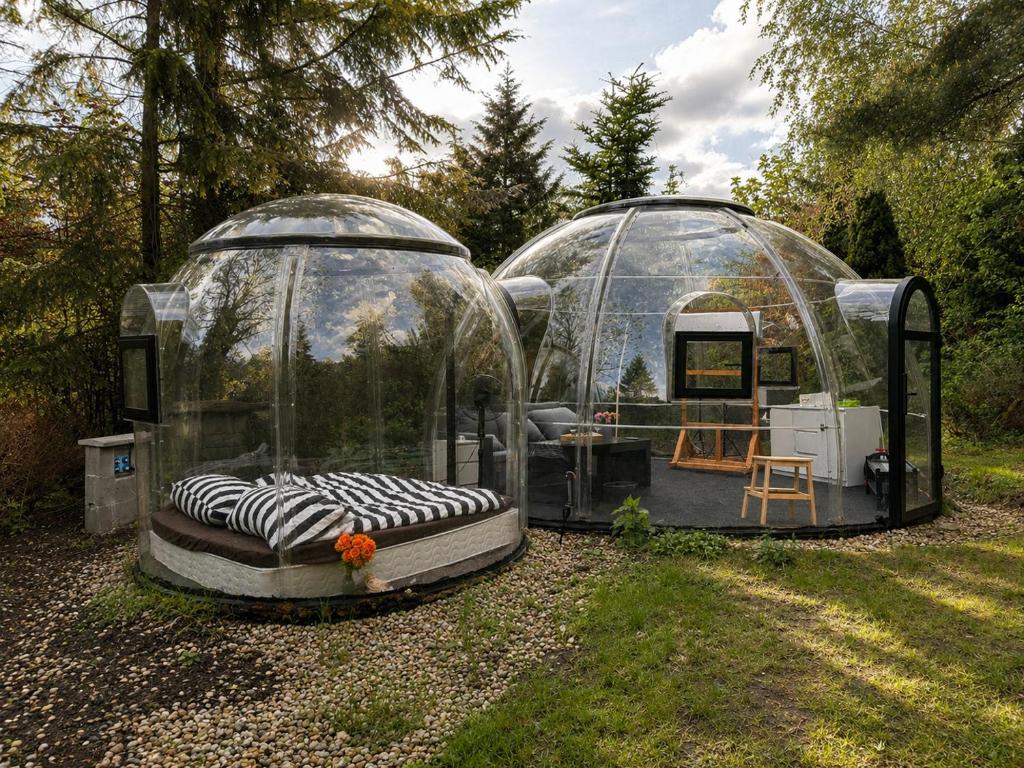 two glass domes with a bed in the yard at Skyhomes Bubble Hotel in Prague