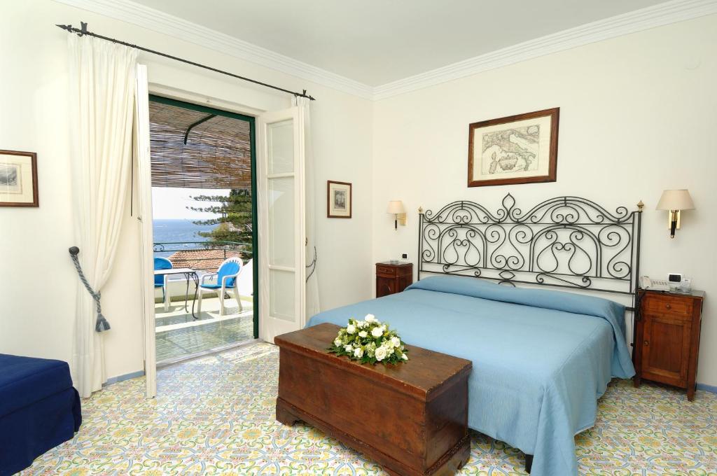 a bedroom with a bed and a table and a window at Hotel Aurora in Amalfi