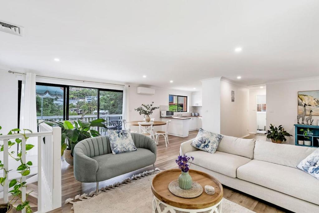 a living room with a couch and a table at North Avoca Coastal Escape in North Avoca