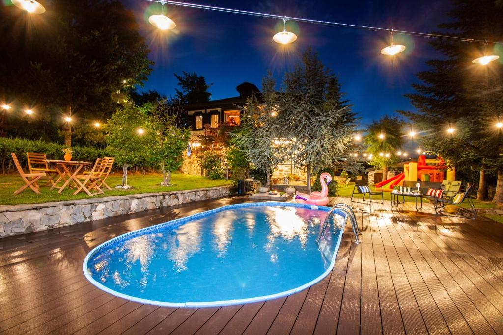 a woman sitting in a swimming pool at night at Дедовата Къща in Dedovo