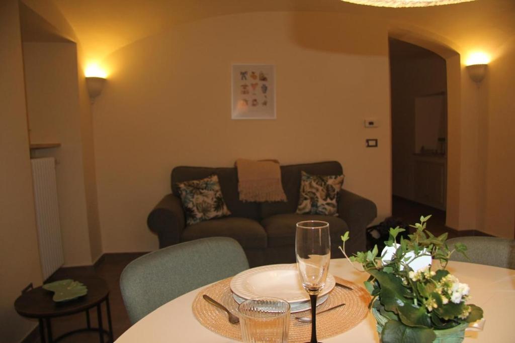 a living room with a table with glasses and a couch at Il nido di Acqui in Acqui Terme