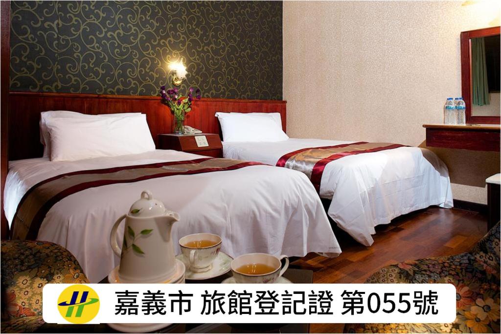 a hotel room with two beds and two cups of coffee at Gene Long Haiy Att Hotel in Chiayi City
