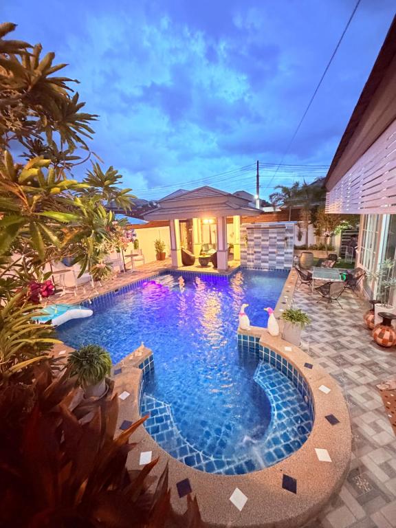 a swimming pool in a backyard at night at Swansea Villa 3 BR in Ban Huai Yai
