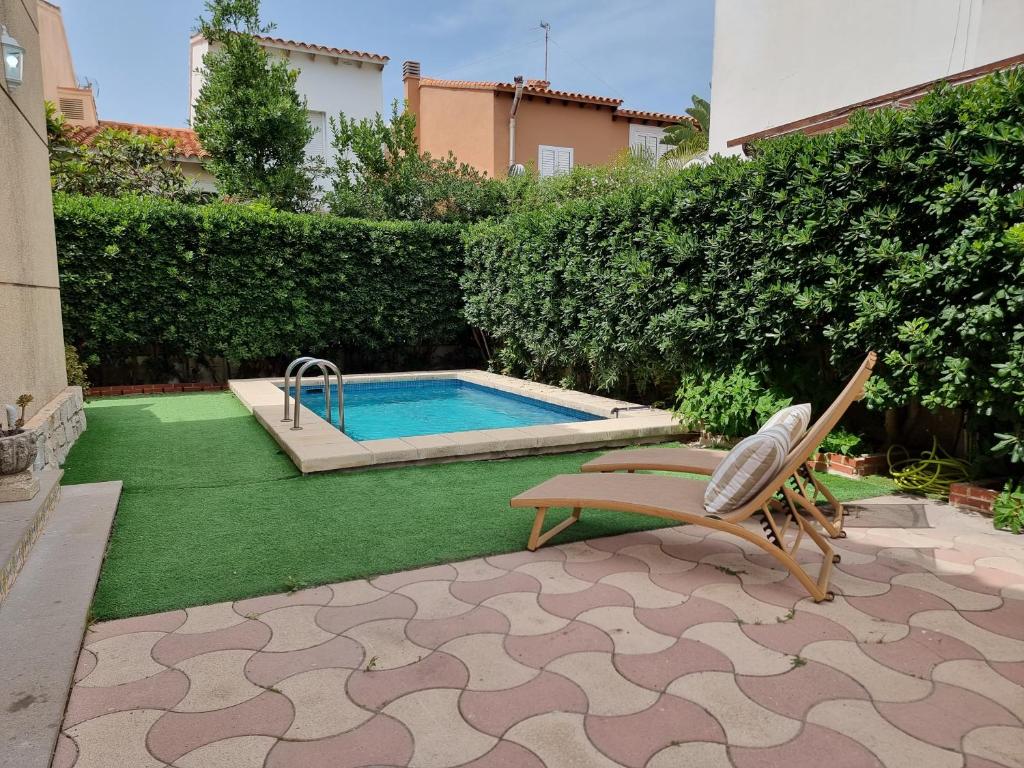 a patio with a chair and a swimming pool at MD Villa con piscina en Mareny Beach in Mareny Blau