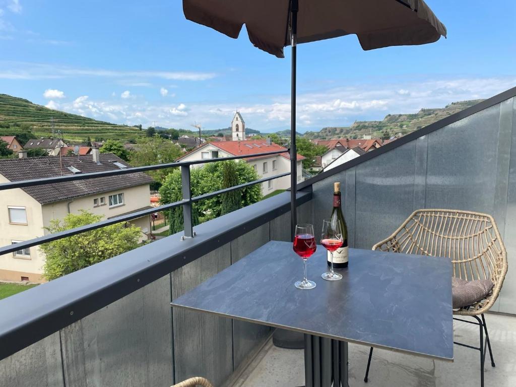 a table with two glasses of wine on a balcony at Apartment Bienenfresser in Vogtsburg