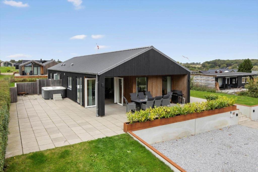 a house with a black roof and a patio at SJ302-Haderslev-Blokhusskoven-63 in Haderslev