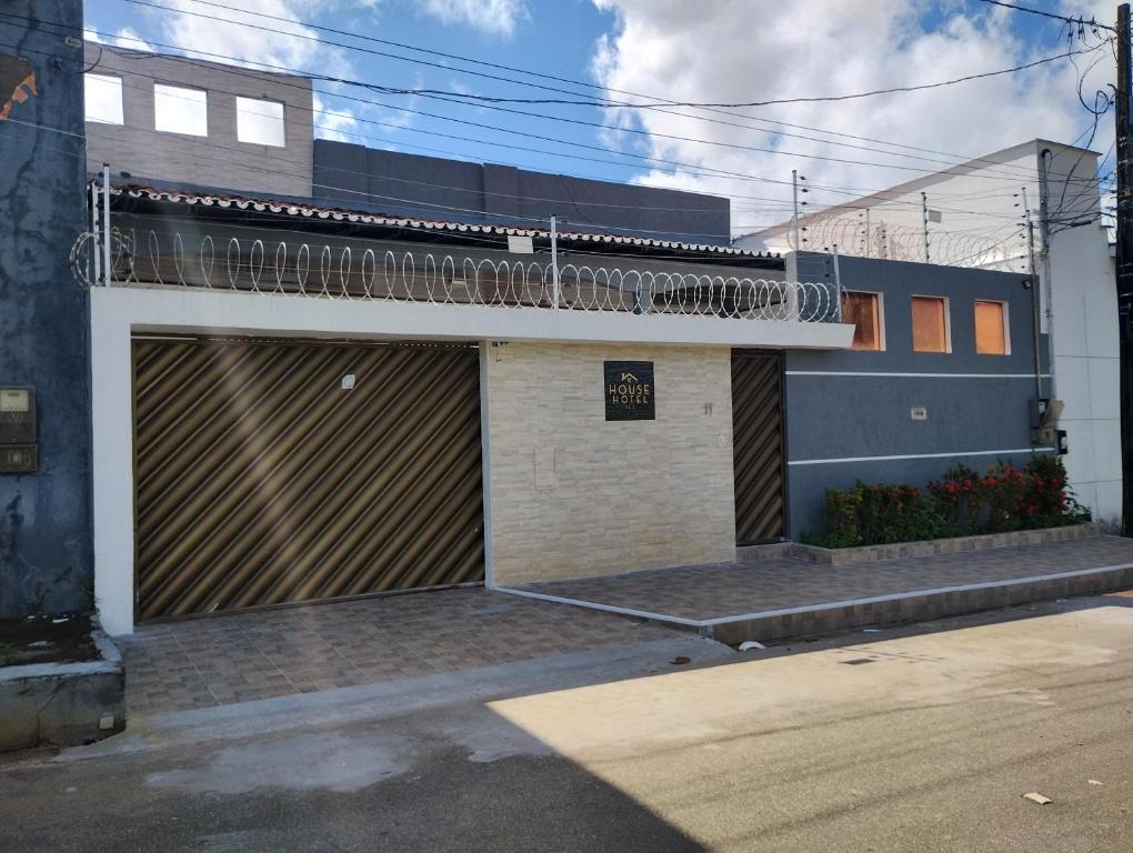 a building with a garage door and a balcony at House Hotel Slz in São Luís