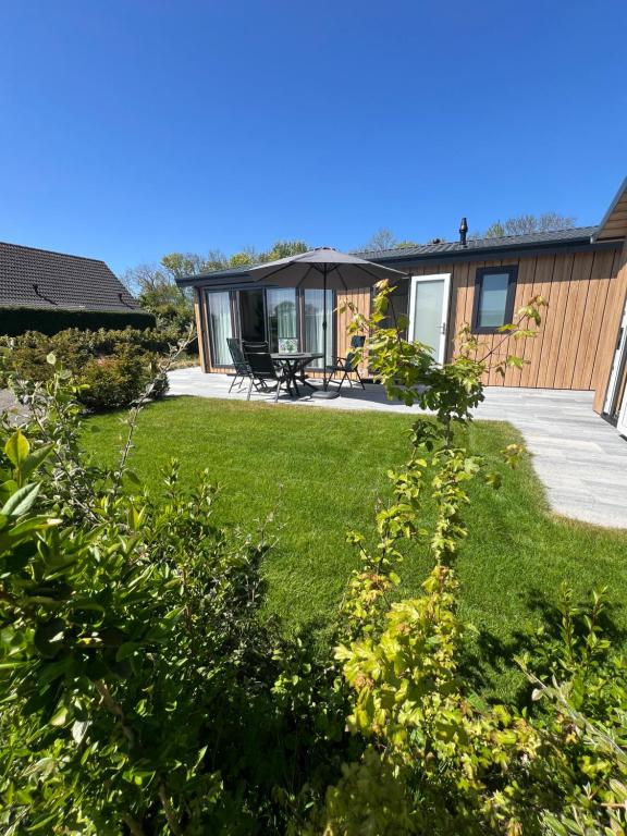 a house with a yard with green grass at Green Flower in Renesse
