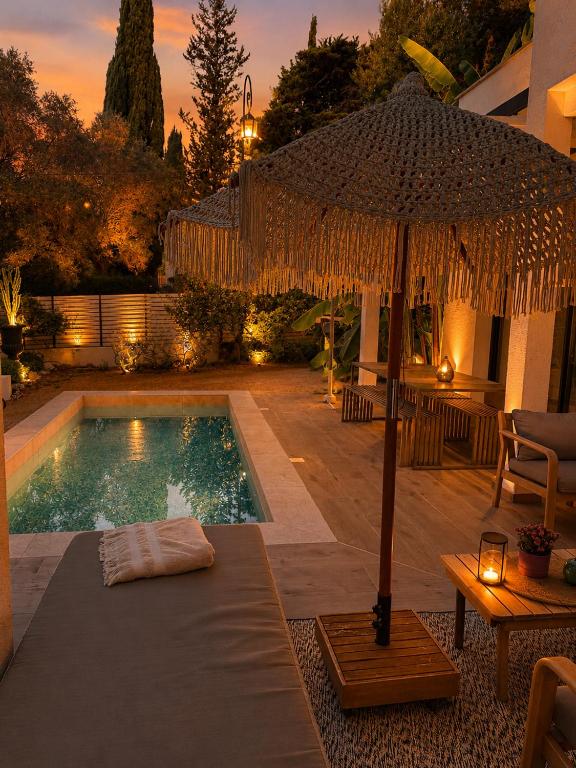 an umbrella sitting next to a swimming pool at Superbe Villa très proche cannes in Mougins