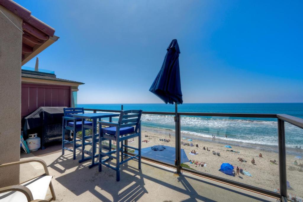 a balcony with a table and chairs and a beach at Oceanfront unit, Private Balcony, Beach Access, Sunset Views in Carlsbad