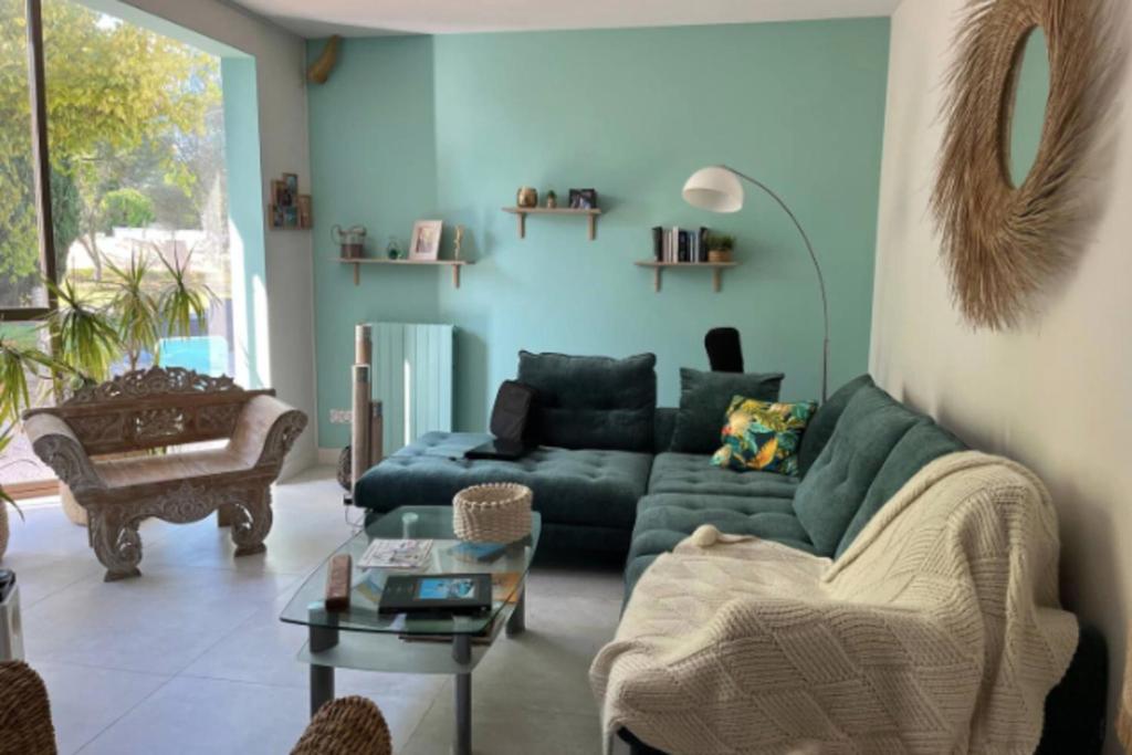 a living room with a green couch and a table at Maison avec jardin & proche plages in Saint-Jean-de-Védas