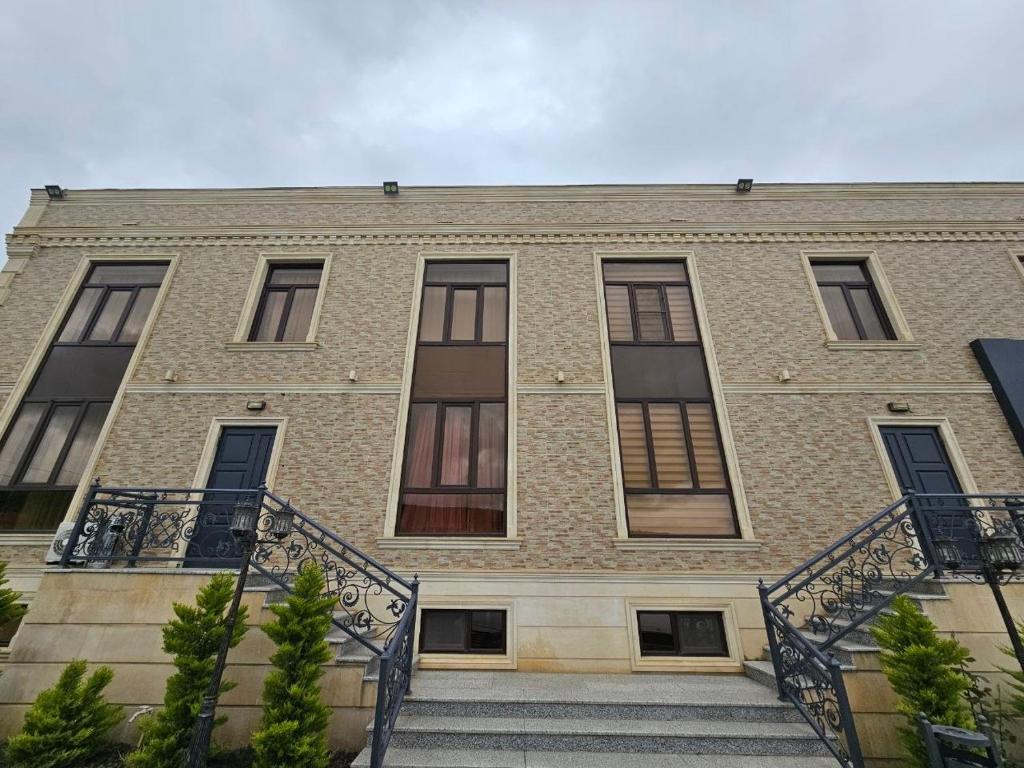 a large brick building with stairs in front of it at Rifah Hotel in Qusar