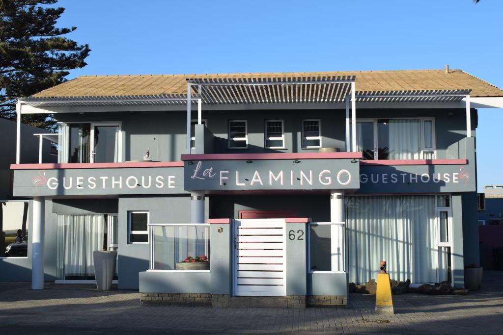 a building with a sign for a guest house at La Flamingo Guesthouse in Walvis Bay