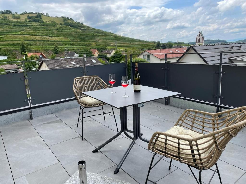 a table with two glasses of wine on a balcony at Apartment Turmfalke in Vogtsburg