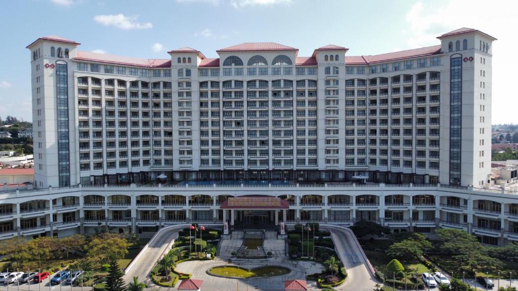 a large building with a courtyard in front of it at Gloria Hotel in Polana Caniço "A"