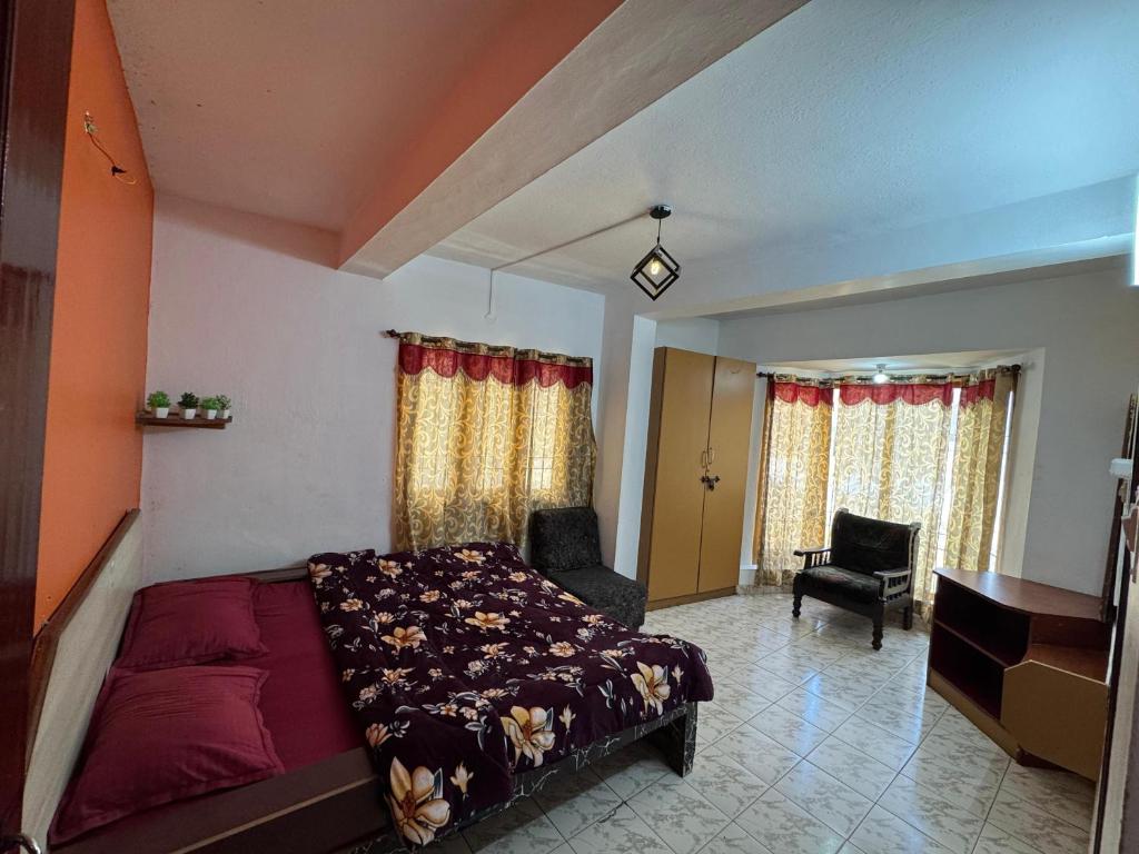 a bedroom with a bed and a chair and a desk at DD cottages in Ooty