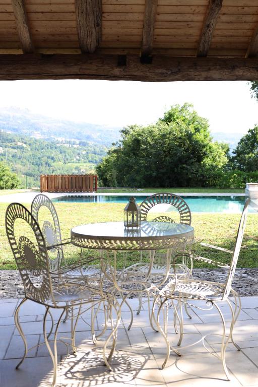 a patio table and chairs on a porch with a view at Retiro Maria Idalina in Amarante
