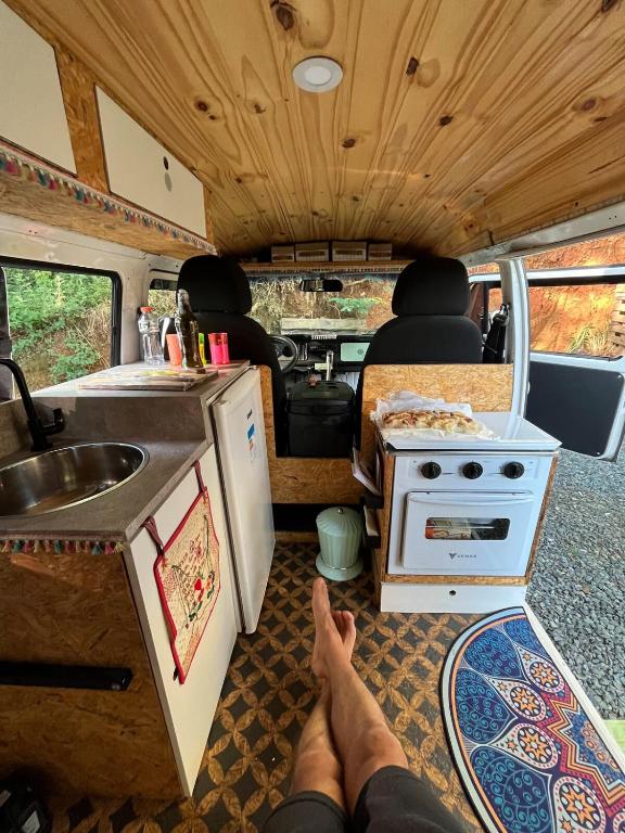 a person laying on the floor of an rv with their feet up at Zíngara - Kombi Home in Brumadinho